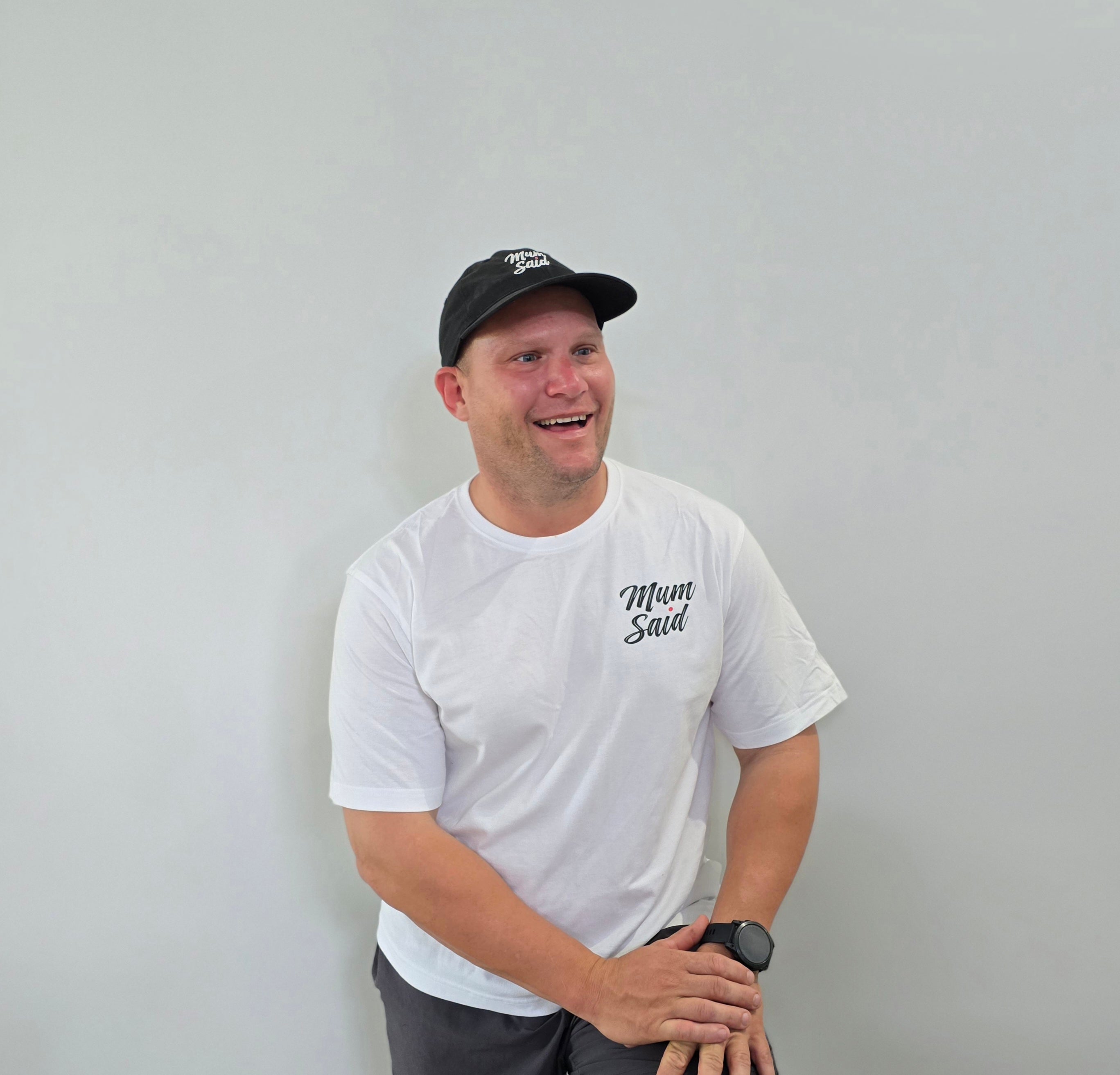 Founder of Mum Said Coffee, Lawrence Polga of the Burdekin, wearing a white t-shirt a black Mum Said logo and a black cap against a plain background. 